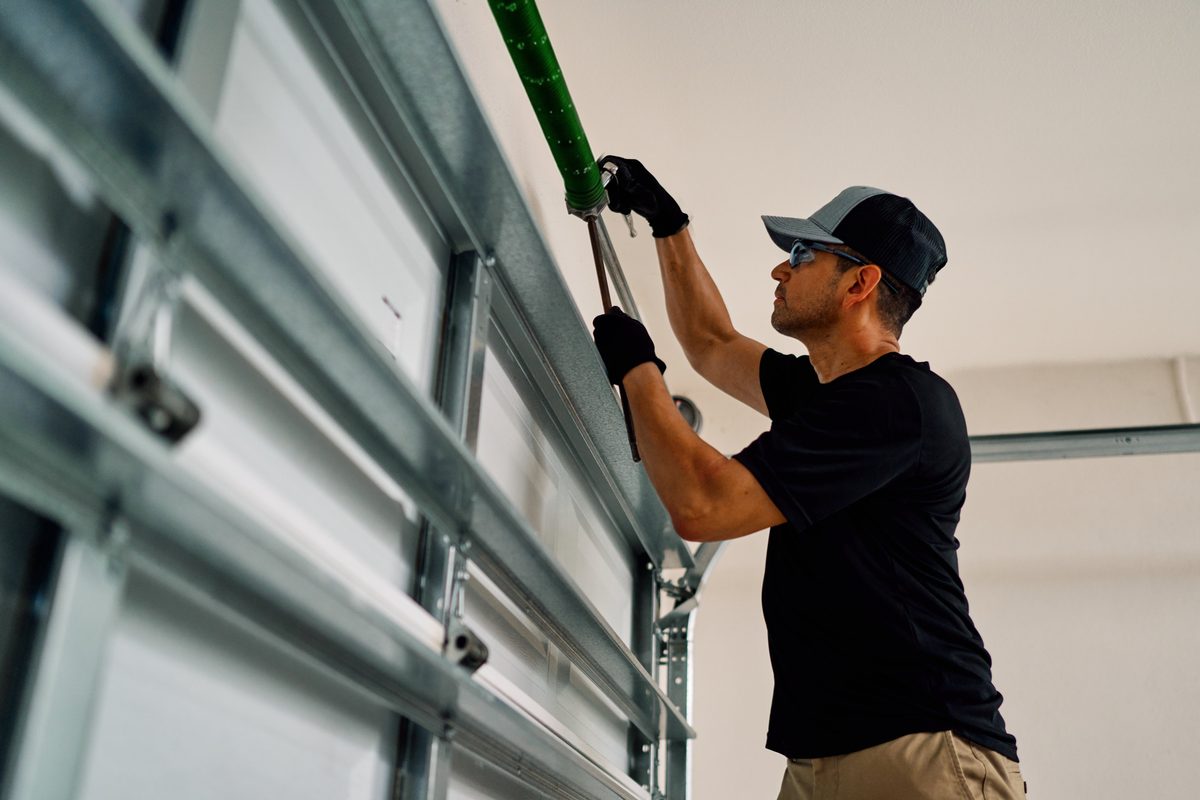 Precision Garage Door technician repairing a garage door spring in Indianapolis